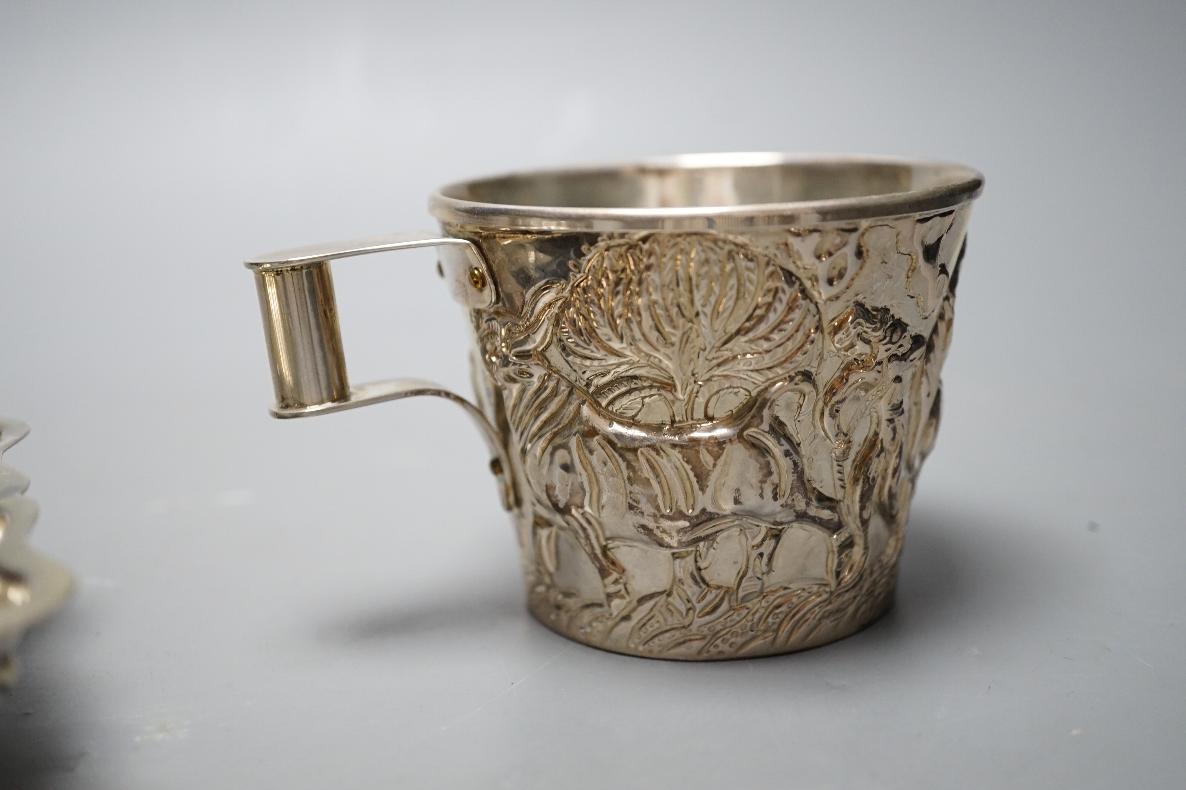 A Greek 900 standard white metal cup, embosses with cattle, height 66mm and a similar dish, gross 10.2oz.